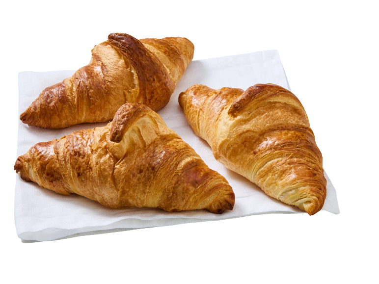 Three golden, crispy croissants on a white cloth.