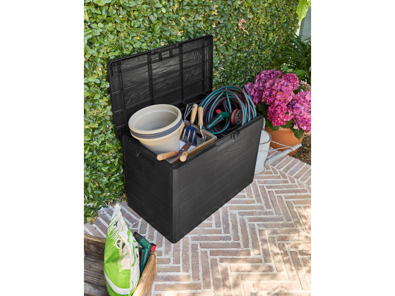 Black garden storage box filled with gardening tools, hose, and flower pot.