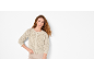 Woman with curly hair and beige knitted cardigan
