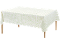 White tablecloth with green and beige geometric pattern on a wooden table.