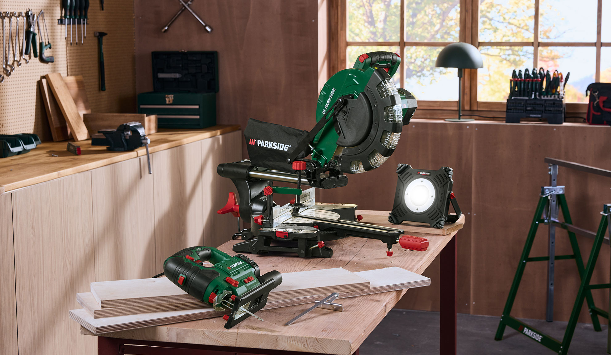 Miter saw, jigsaw, and work light in a woodworking workshop.