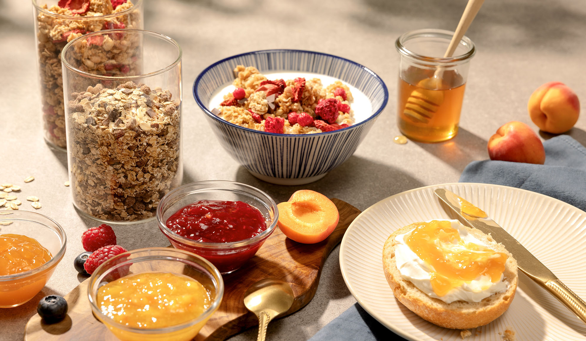 Breakfast with granola, honey, jam, and fresh fruit.