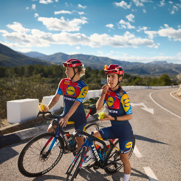 Two Trek-Segafredo Lidl cyclists enjoy a break with fruit.