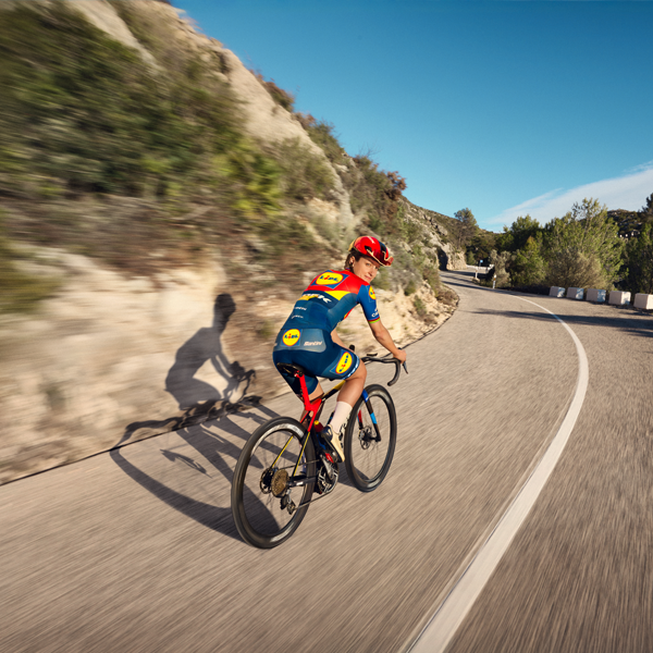 Cyclist on road bike in mountain landscape.