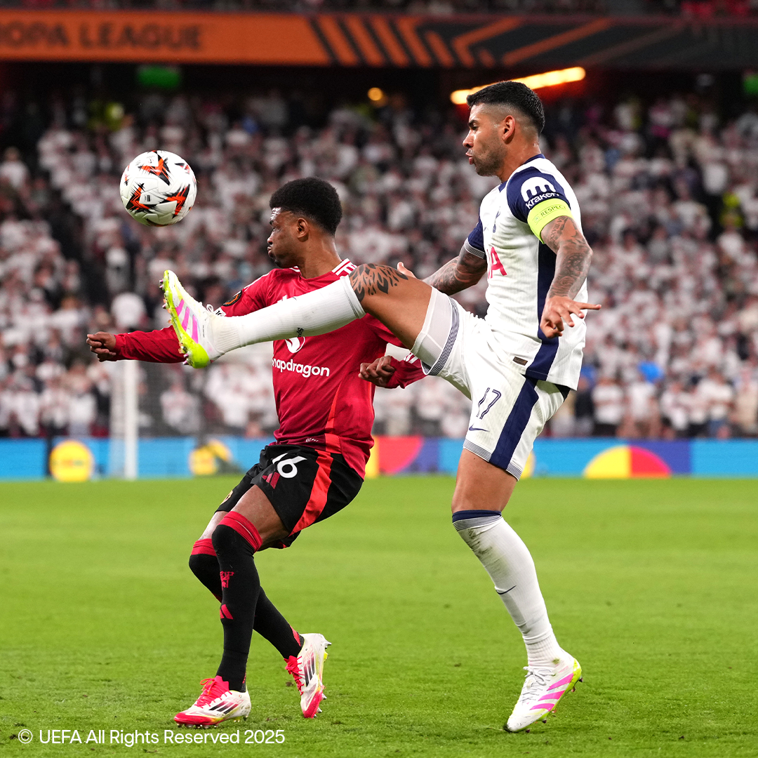 Two footballers in Adidas and Nike gear battle for the ball on the field.