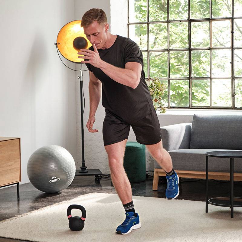 Man trains with Crivit medicine ball, kettlebell and gym ball