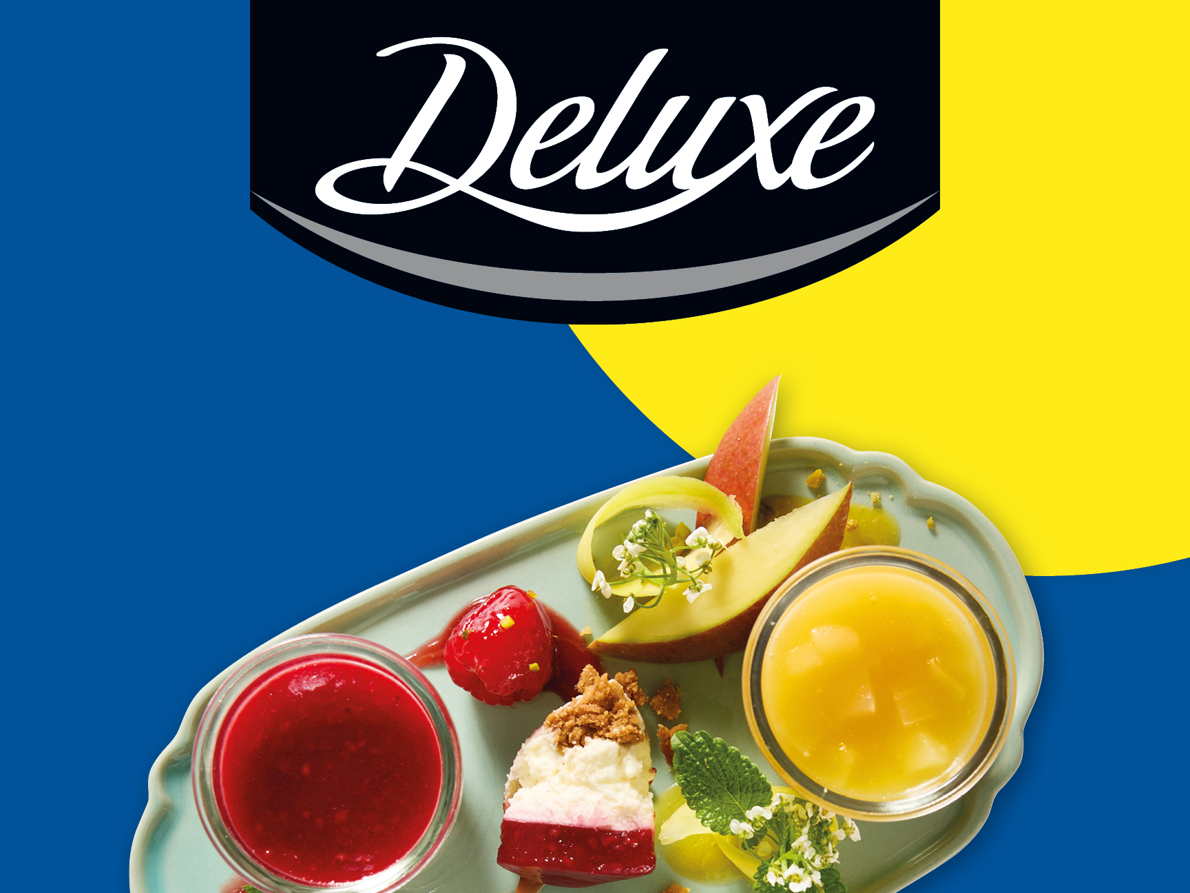 Deluxe brand dessert platter featuring cheesecake, fruit, and fruit sauces.