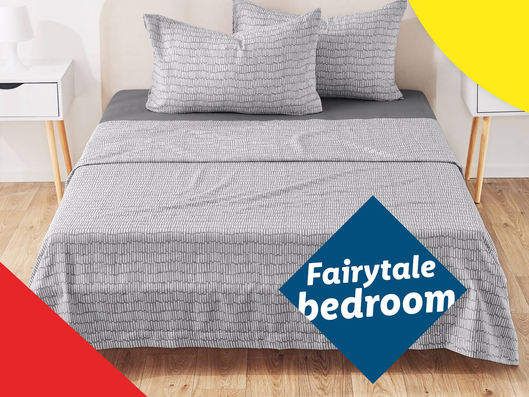 A bed with gray and white patterned bedding, including pillows and a duvet, in a room with wooden floors and white nightstands.