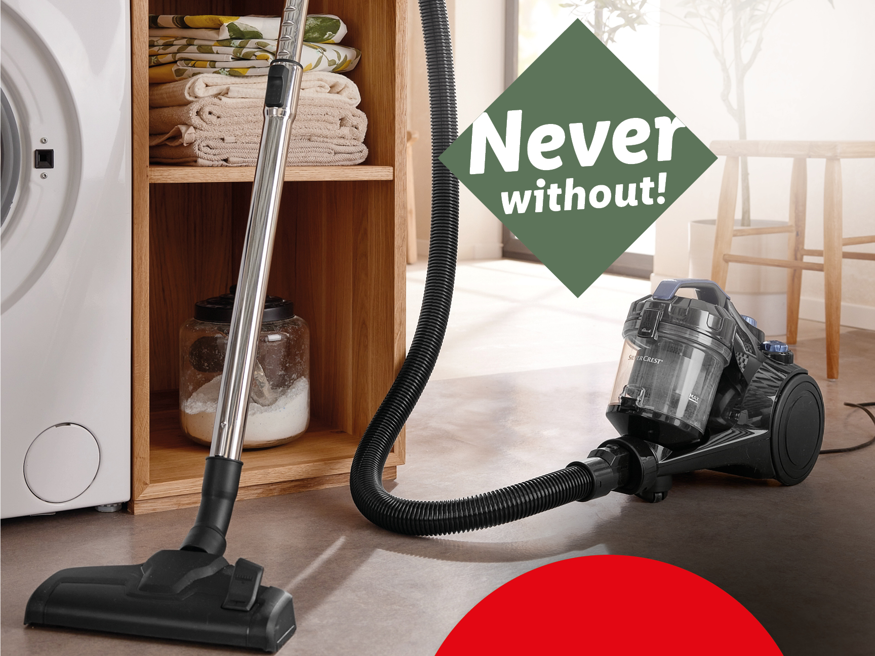 A vacuum cleaner with a hose and nozzle, next to a washing machine and wooden shelves.