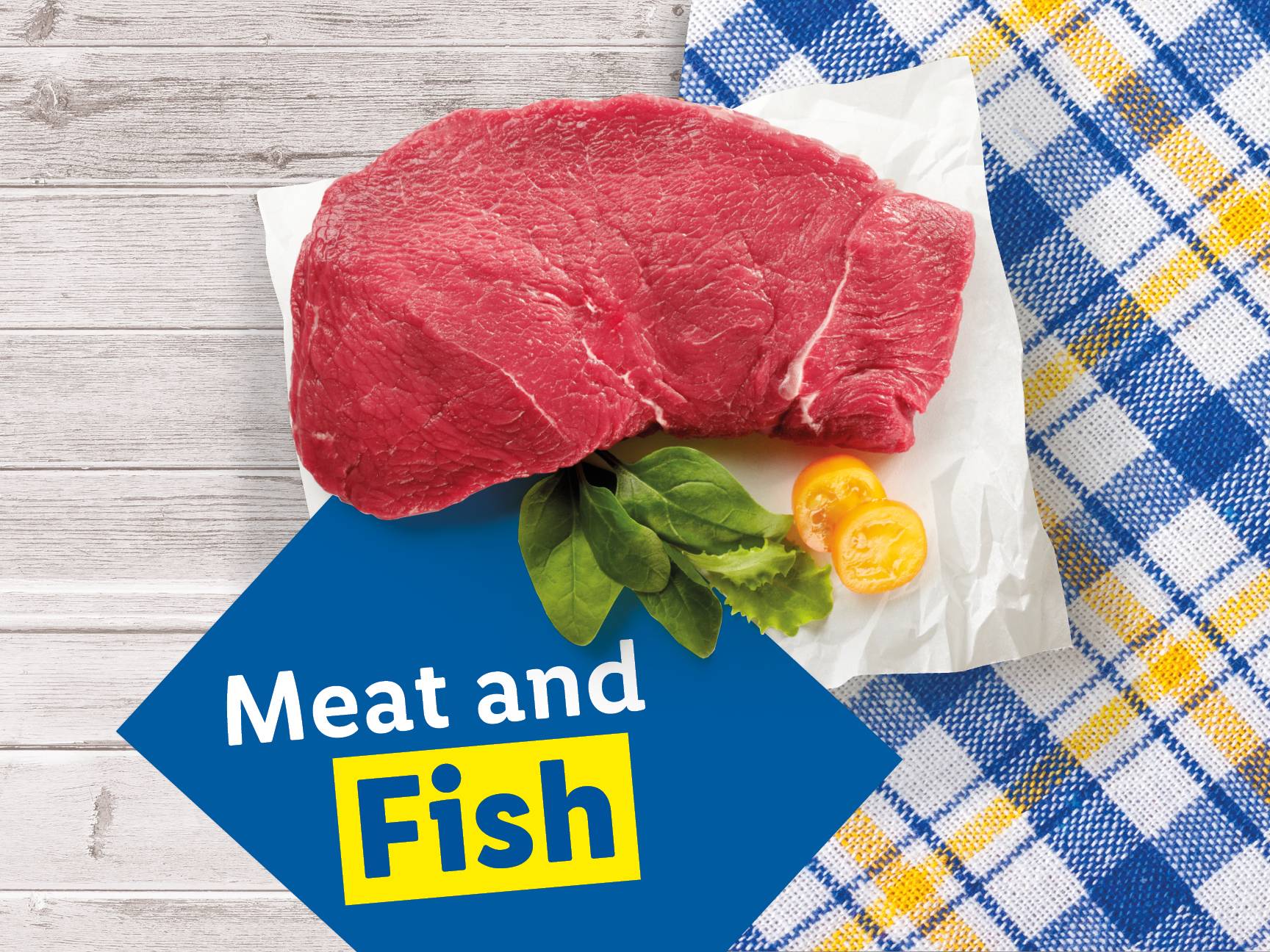 Raw meat with greens and tomatoes on a white paper, with a blue and yellow checkered cloth.