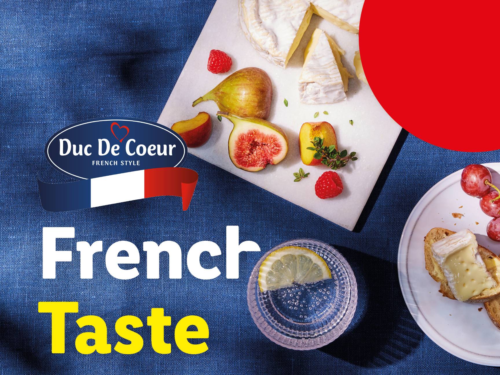 A Duc De Coeur French Style cheese board with figs, raspberries, and a drink, promoting 'French Taste'.