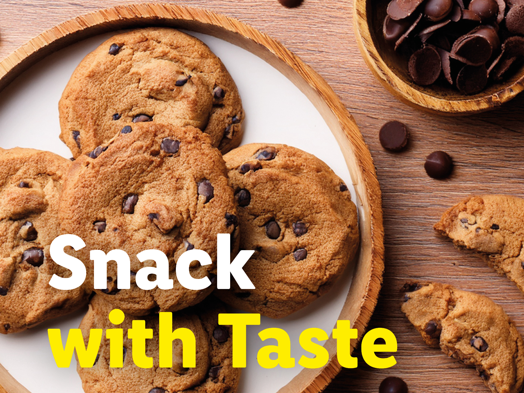 Chocolate chip cookies on a wooden tray with chocolate chips scattered around.