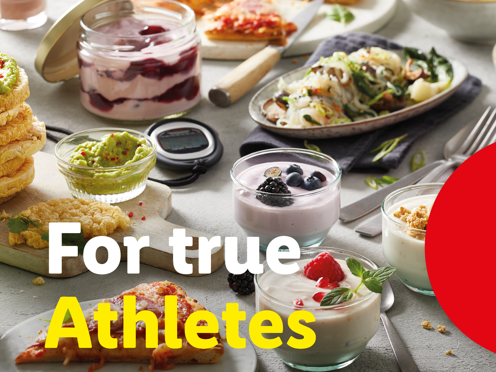 A spread of healthy foods including yogurts, rice cakes with guacamole, and a noodle dish.