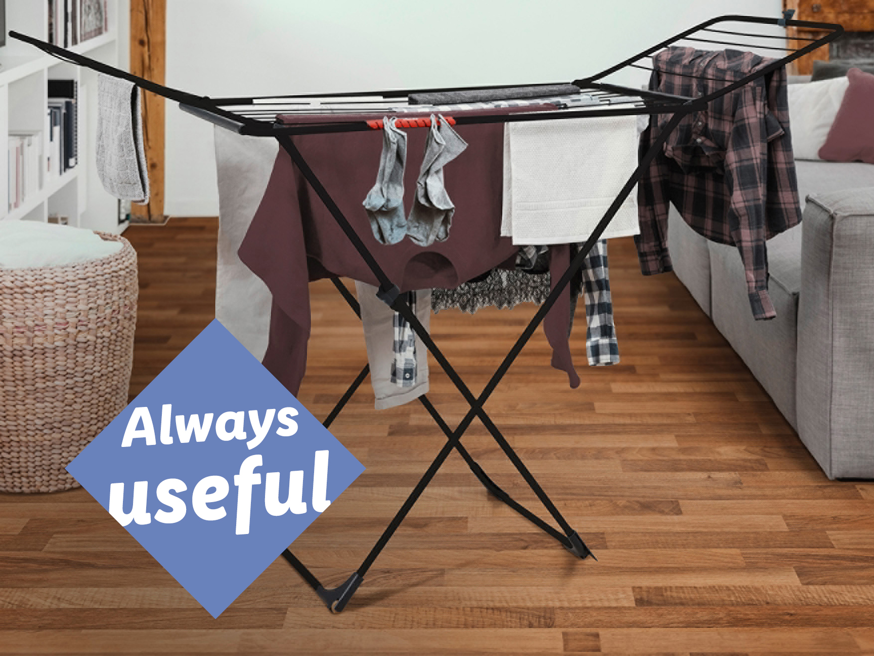 A black clothes drying rack with various garments hanging on it in a living room.
