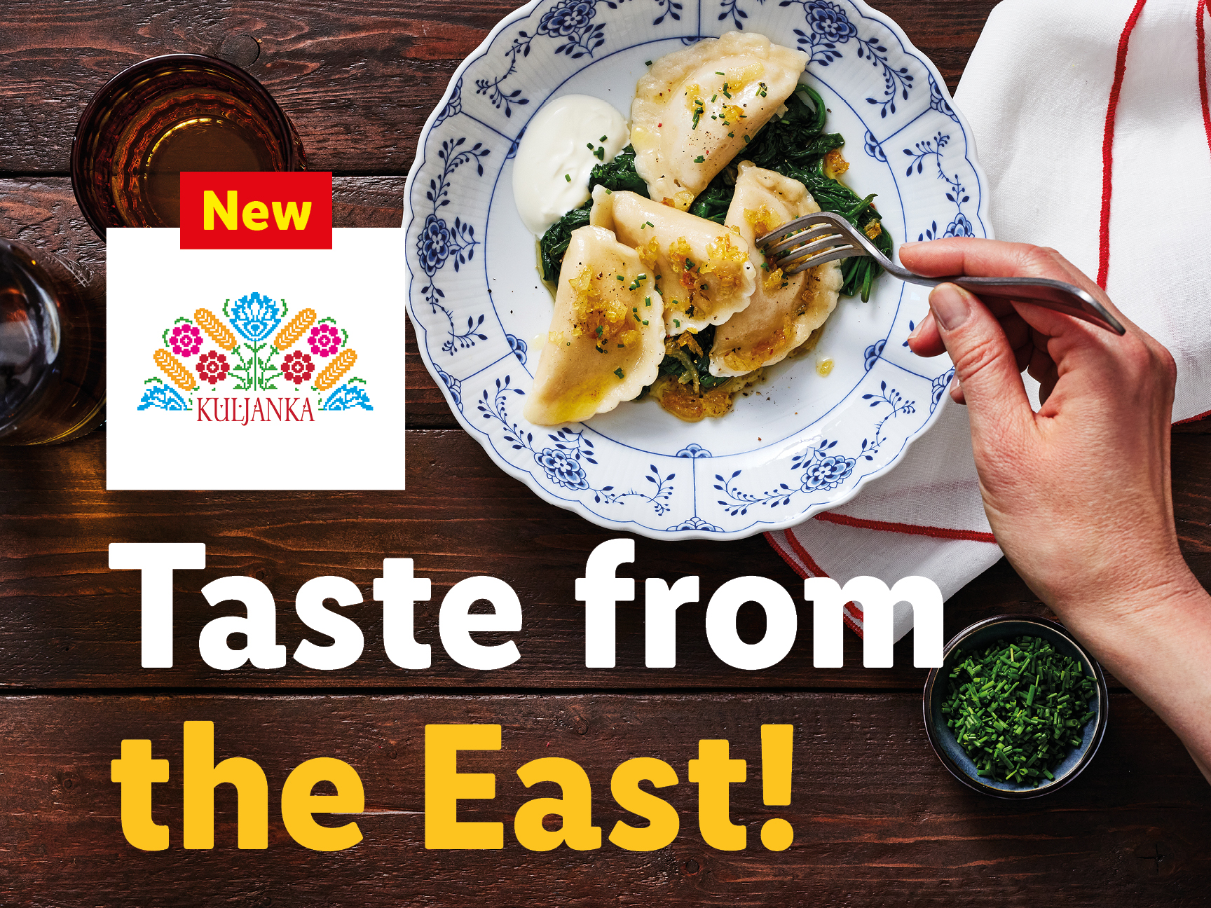 A plate of pierogi with spinach and sour cream, next to a KULJANKA logo and text.
