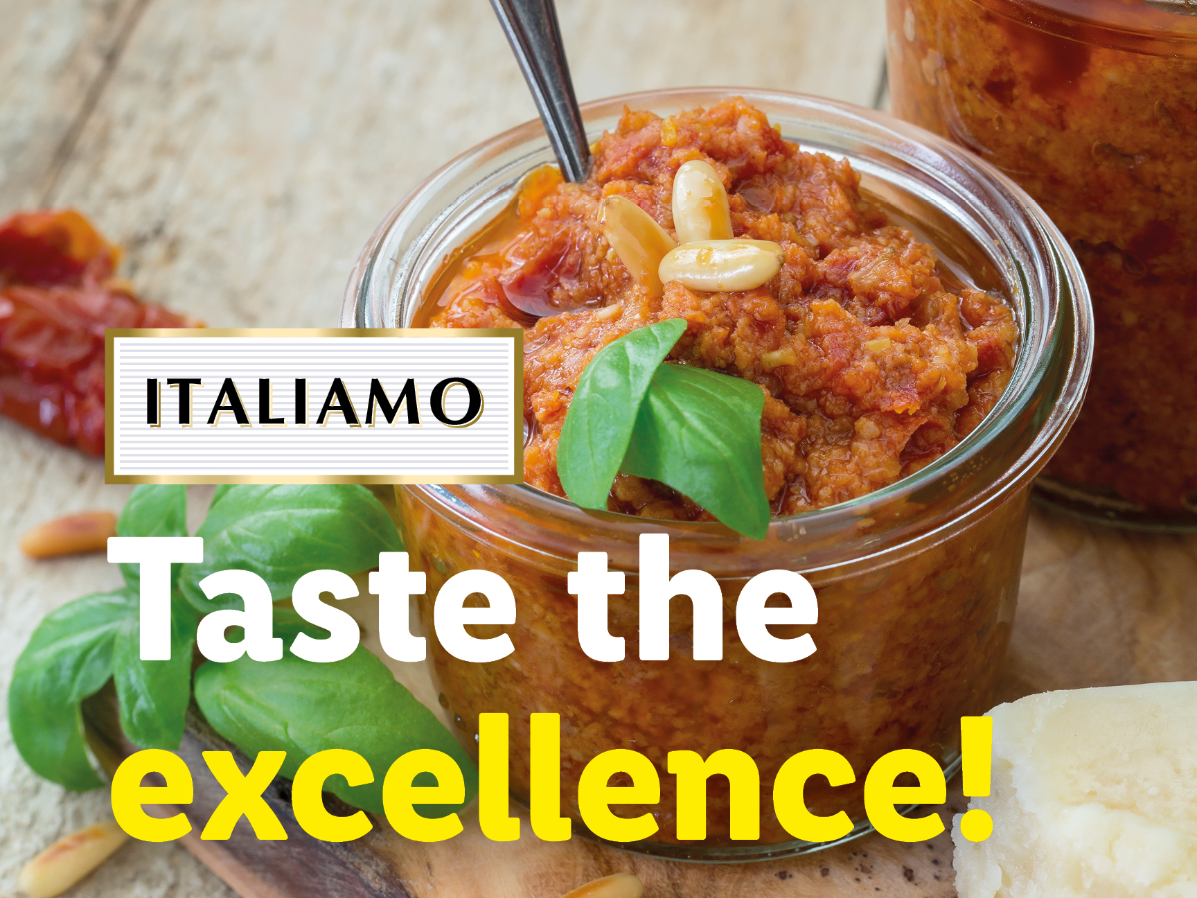 A jar of red pesto with pine nuts and basil, next to a block of cheese, with text 'ITALIAMO Taste the excellence!'