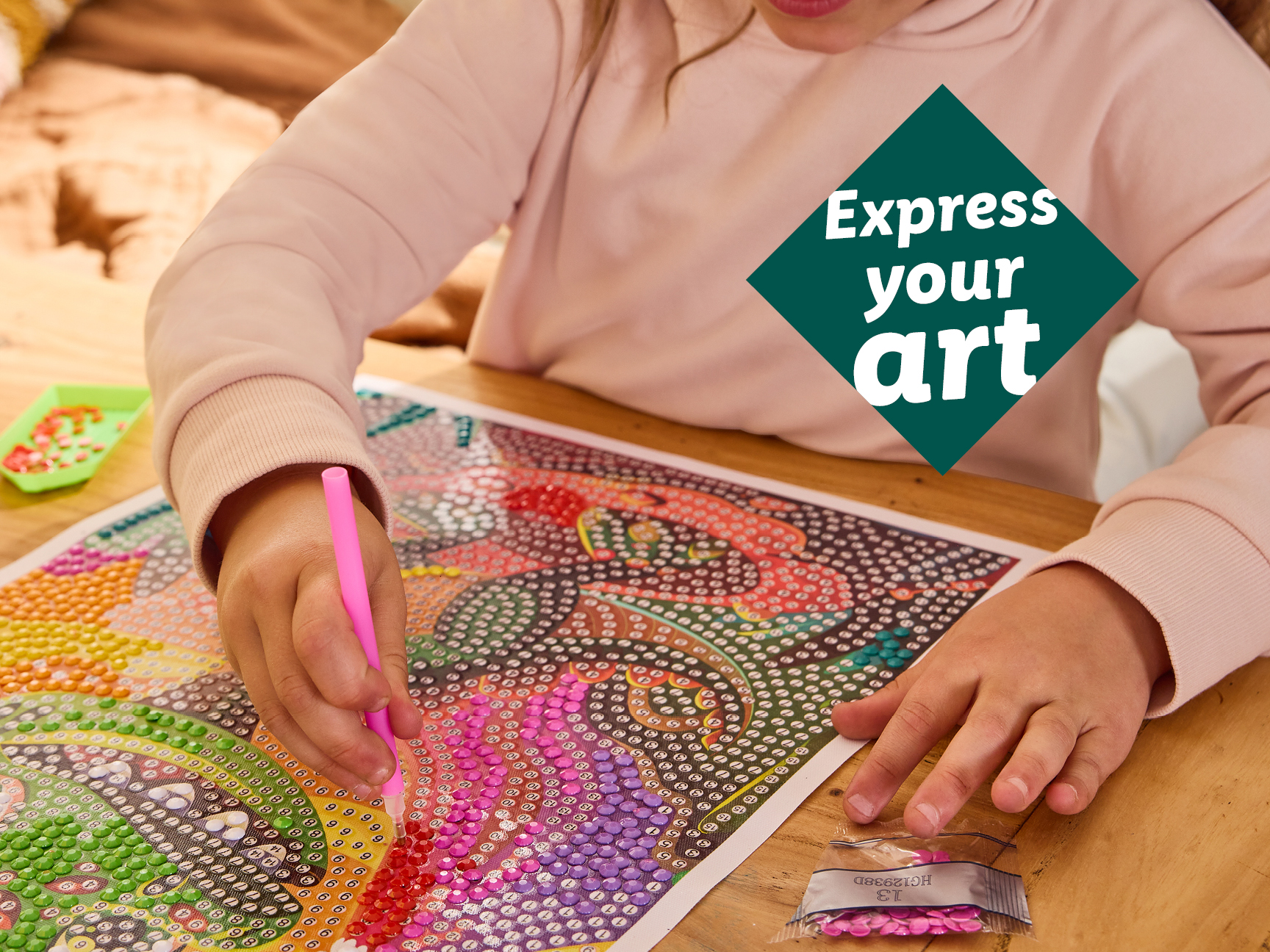 A child doing a diamond painting craft with a pink pen.