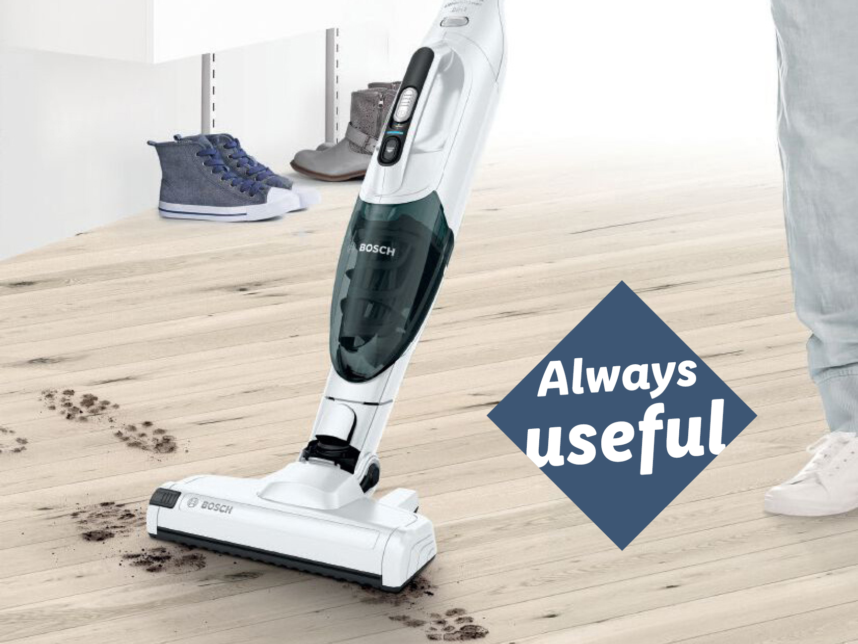 A Bosch vacuum cleaner cleaning dirt tracks on a wooden floor, with shoes in the background.