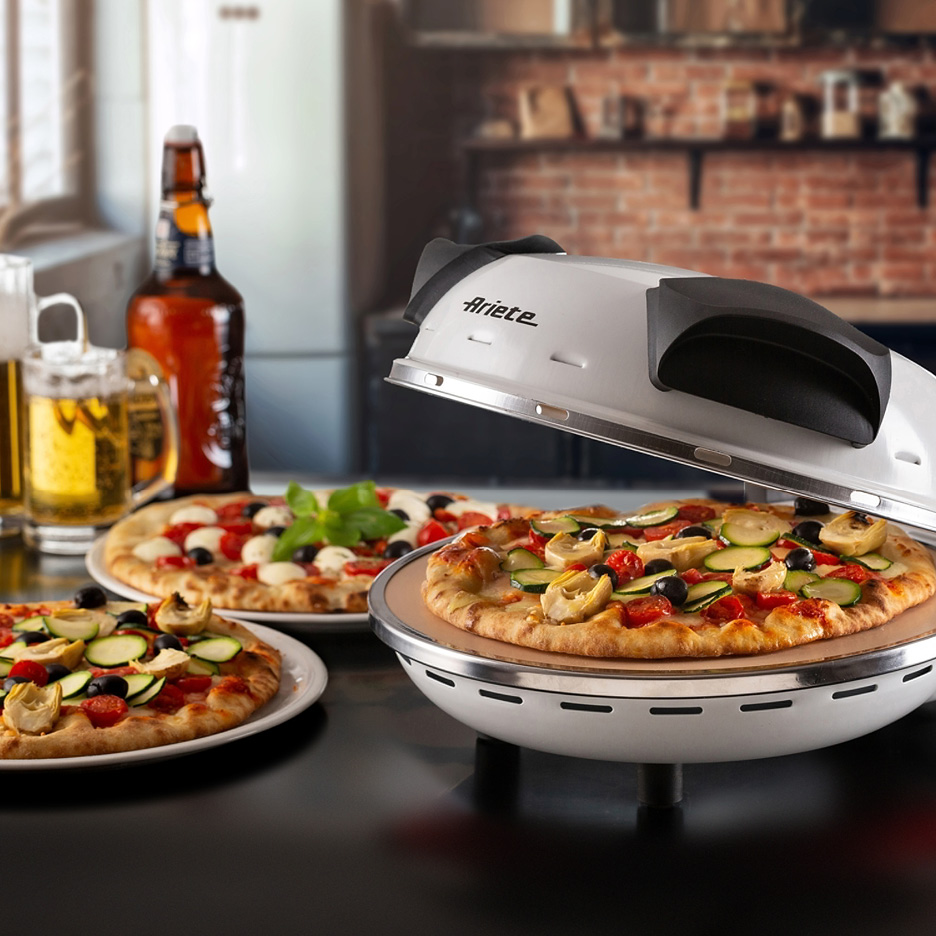 Ariete pizza oven with a pizza inside, surrounded by other pizzas and beer.