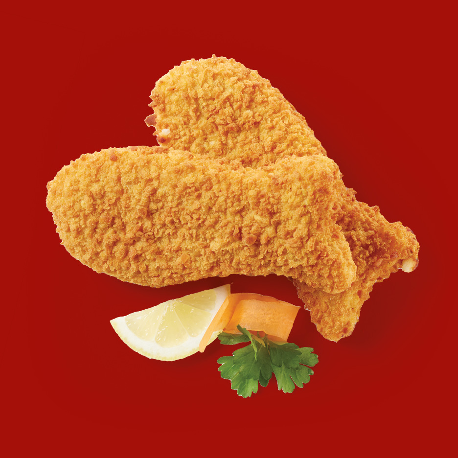 Two breaded fish fillets with a lemon wedge, carrot, and parsley on a red background.