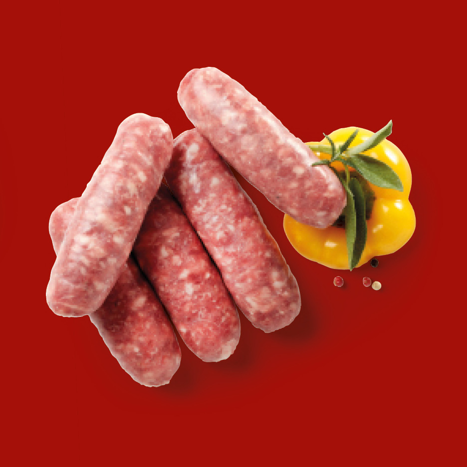 Raw sausages with a yellow bell pepper and herbs on a red background.