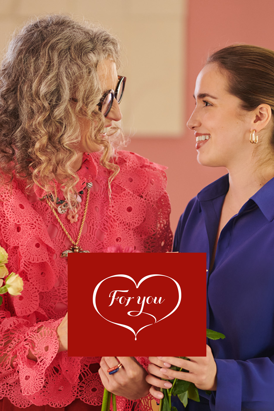 Two women exchanging flowers and a red card with 'For you' in a heart.