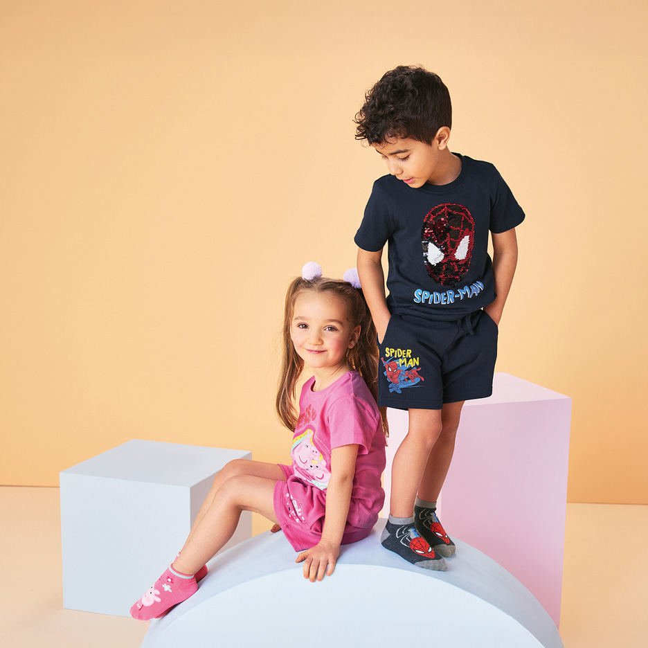 Boy in navy Spider-Man t-shirt and shorts, girl in pink Peppa Pig t-shirt and shorts.
