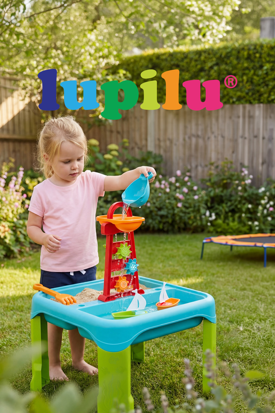 Child playing with a sand and water table featuring a water mill in a garden.
