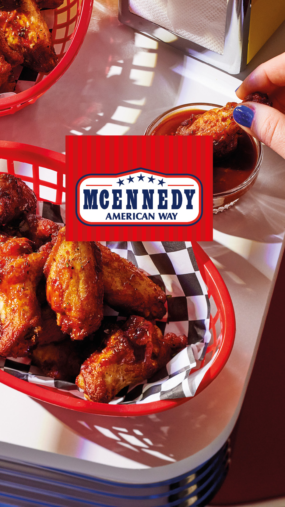 Chicken wings in red baskets with a person dipping one into sauce, American Way logo.