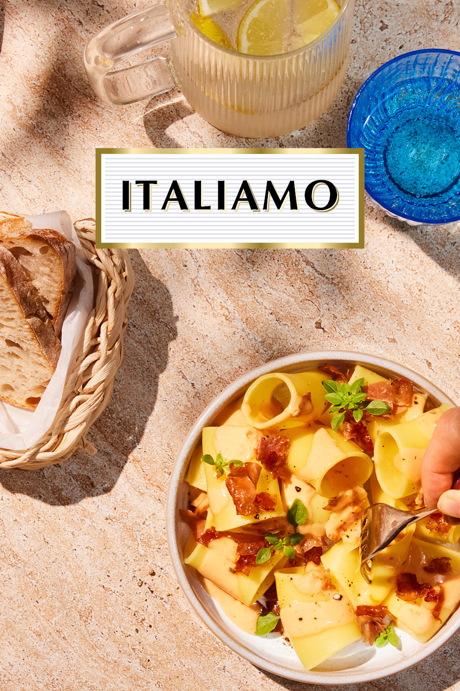 Pasta with bacon and basil, bread, and lemonade on a sunny table with 'ITALIAMO' text.