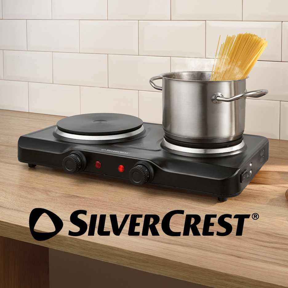 Black double hot plate with a pot of spaghetti cooking on a wooden countertop.