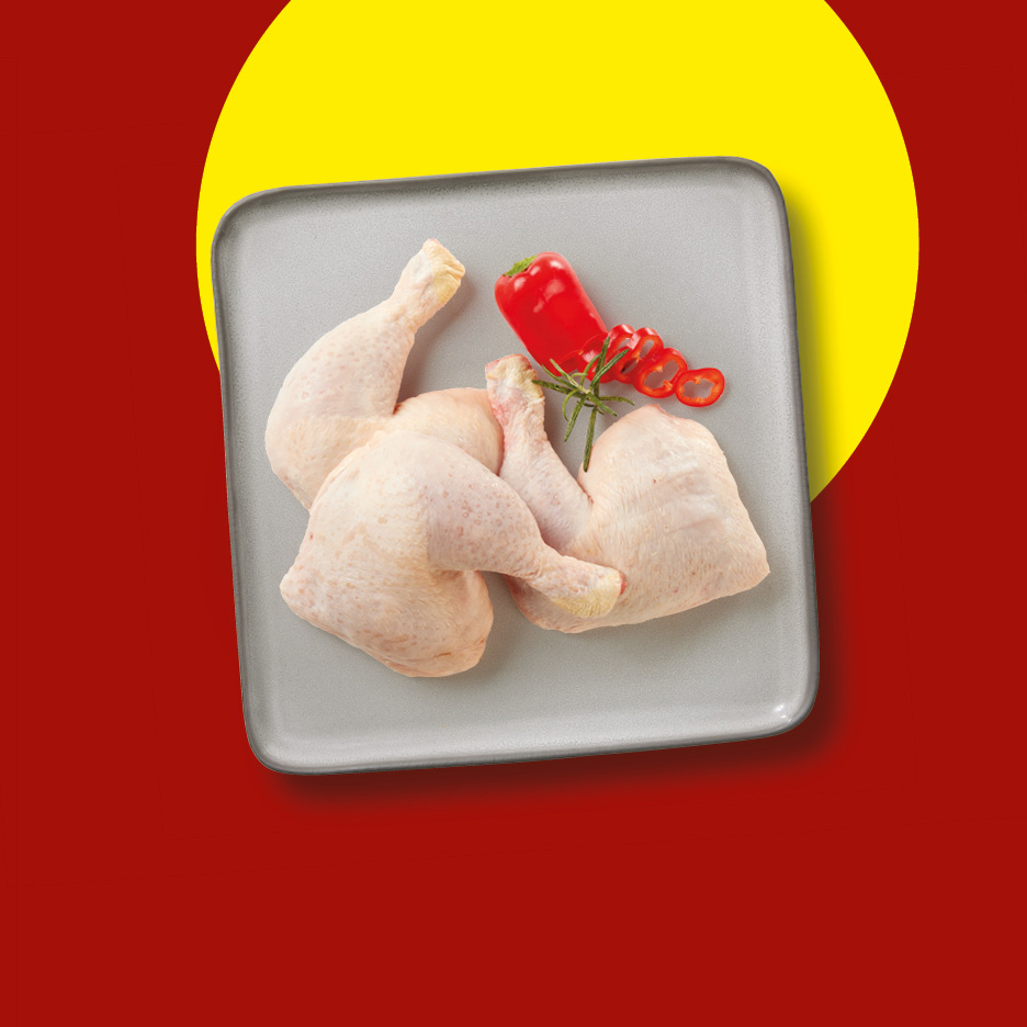 Raw chicken leg quarters with red pepper and rosemary on a grey tray.