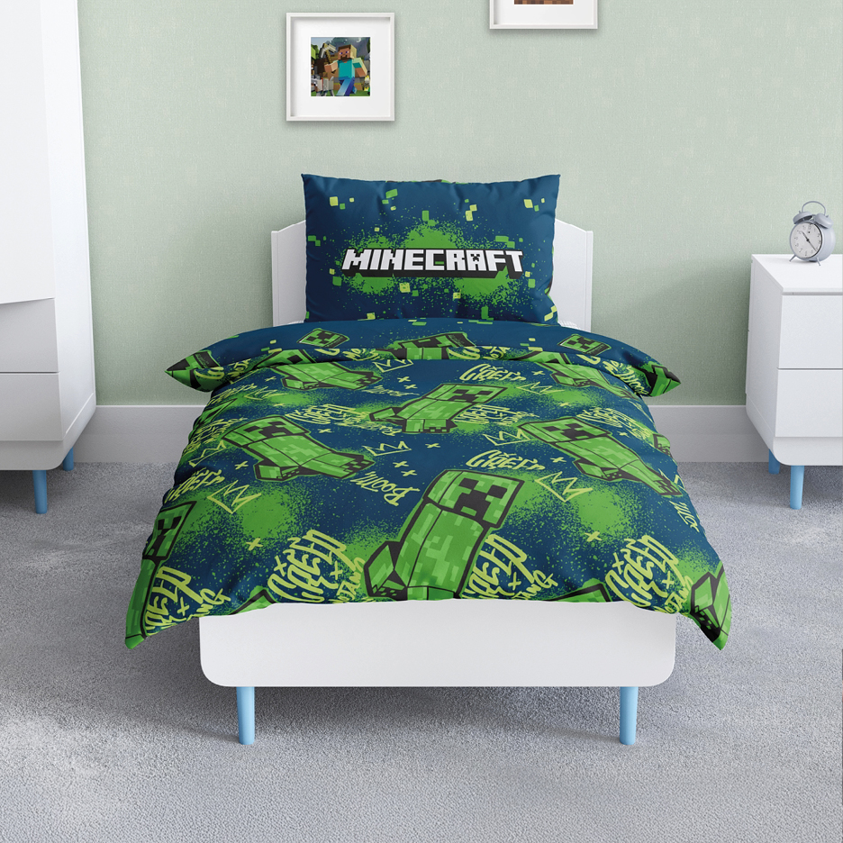 A child's bed with Minecraft-themed duvet cover and pillow in a bedroom.