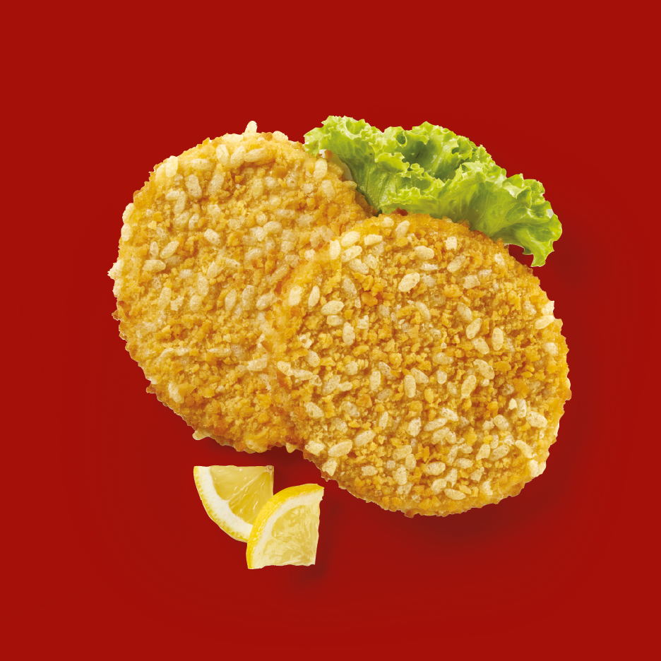 Two crispy breaded fish cakes with lettuce and lemon wedges on a red background.