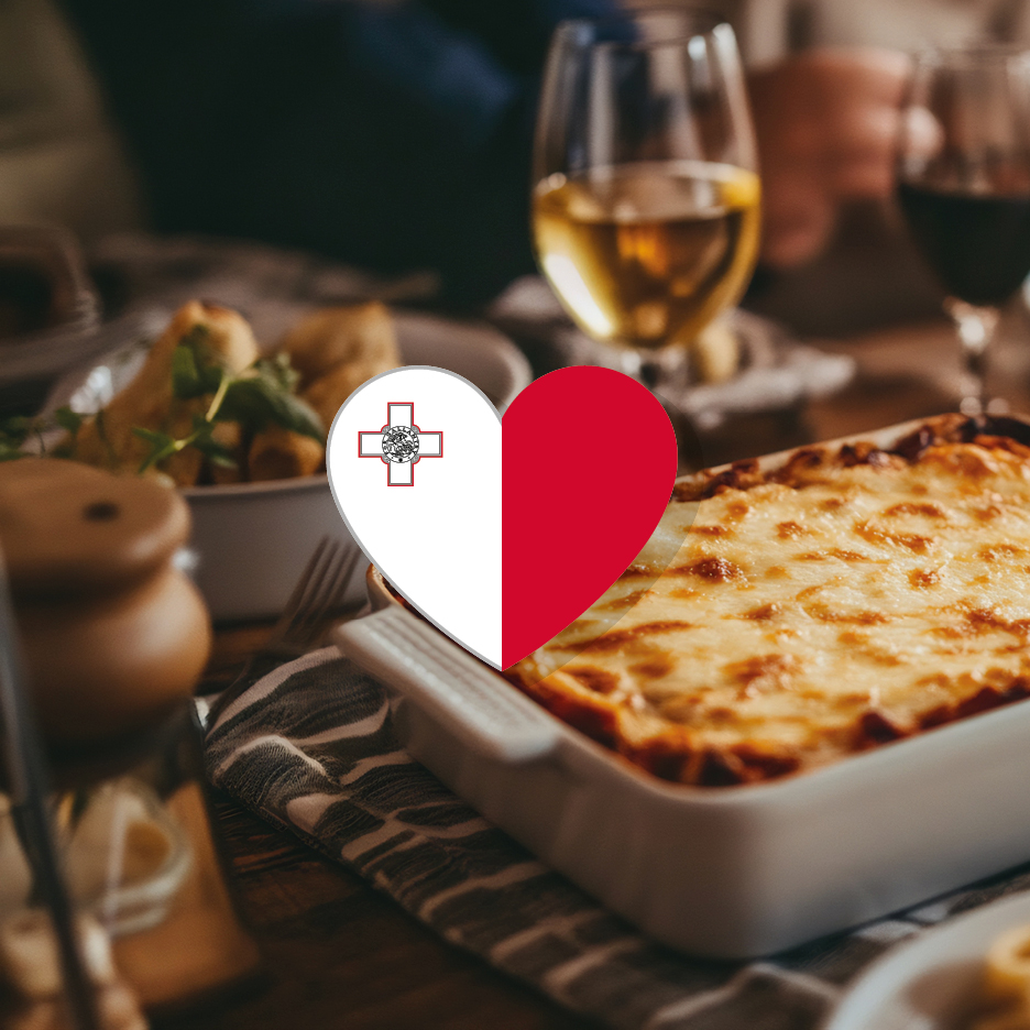 A heart-shaped Maltese flag overlaying a table with lasagna, wine, and other dishes.