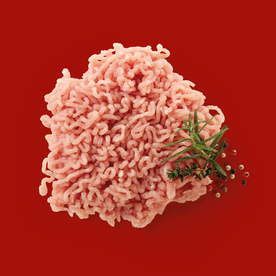 Ground chicken or turkey with rosemary, thyme, and peppercorns on a red background.