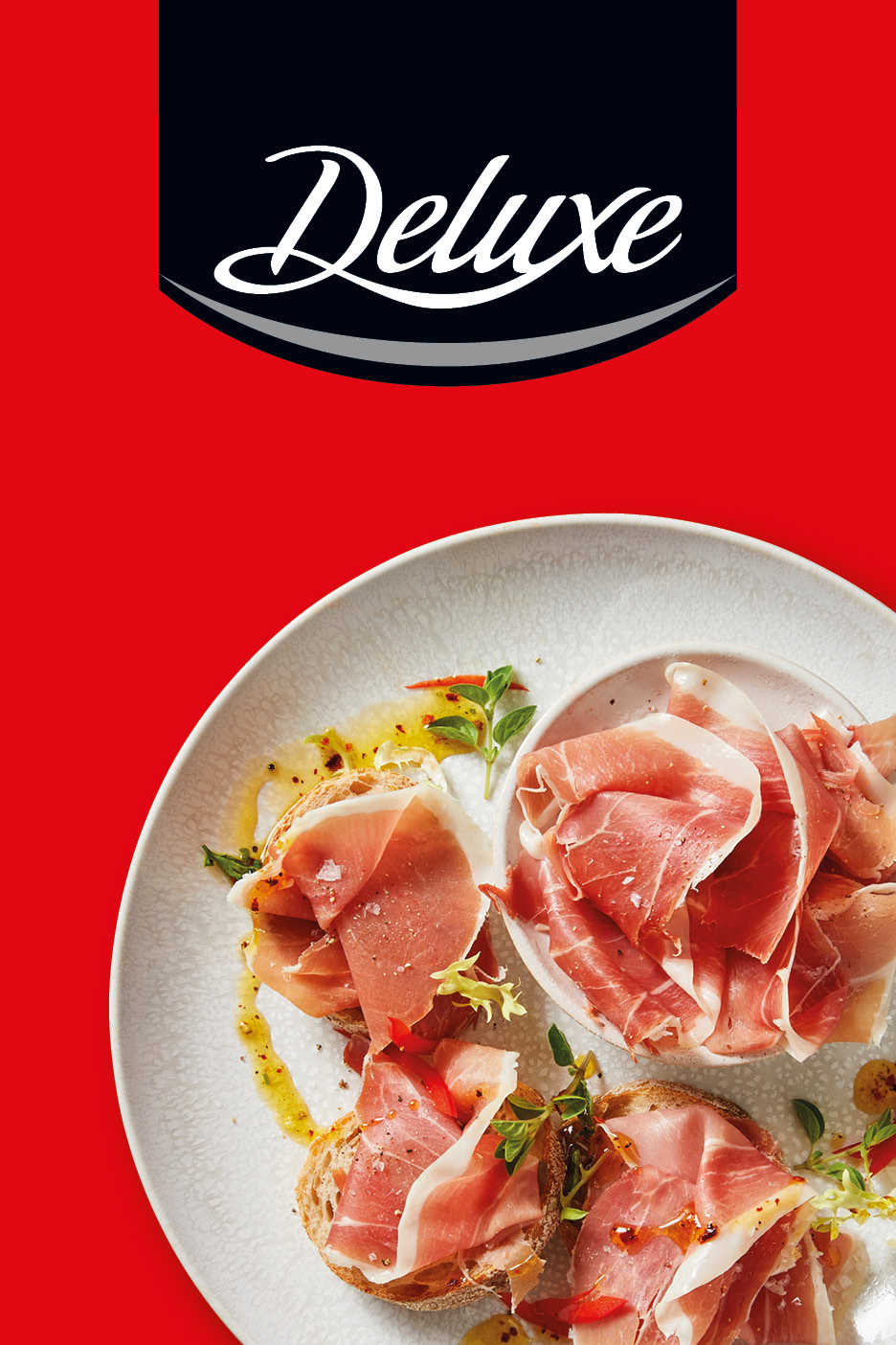 Deluxe cured ham served on bread with olive oil and herbs on a plate.
