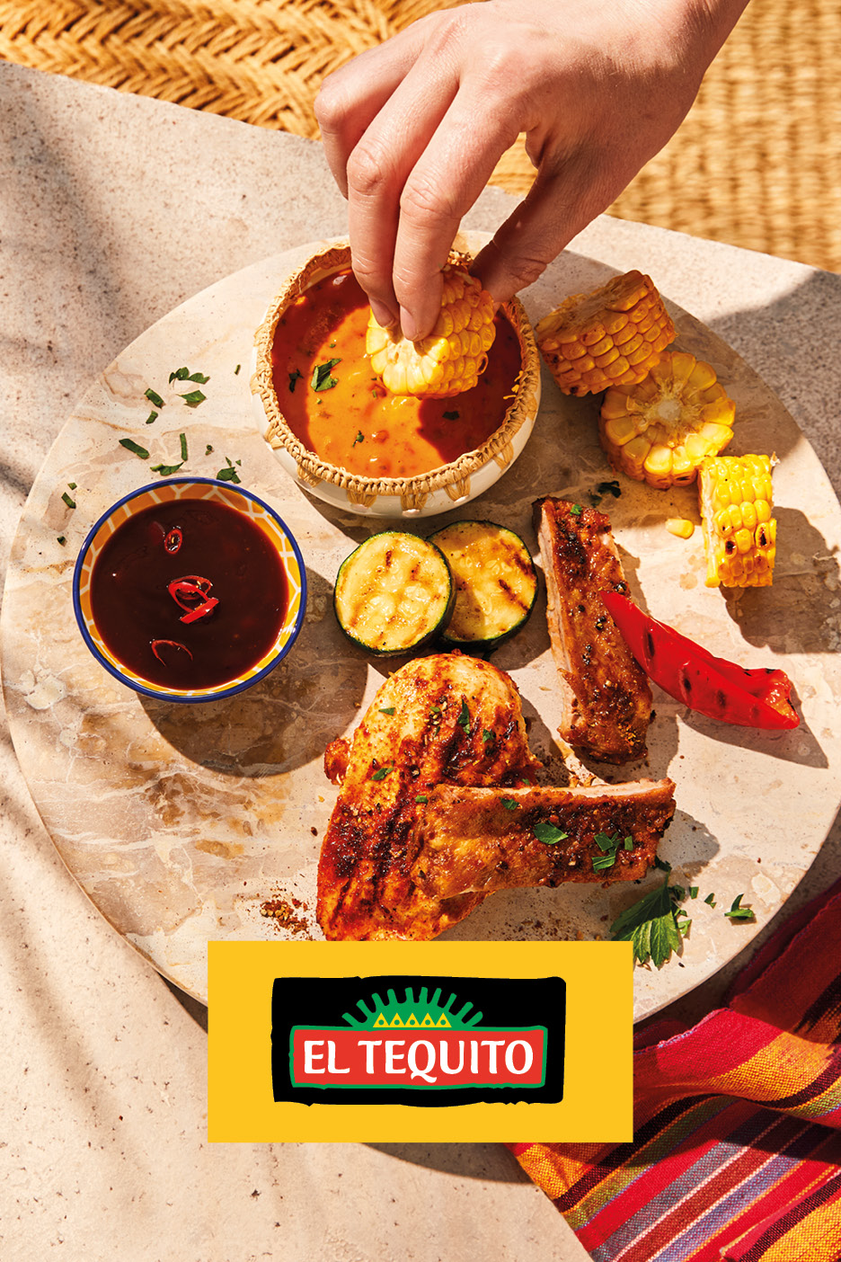 Grilled chicken, ribs, corn, and zucchini served with dipping sauces on a stone platter.