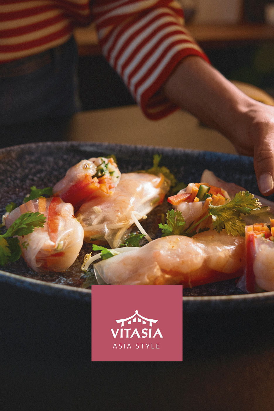 Fresh summer rolls served on a dark plate with Asian-style branding.