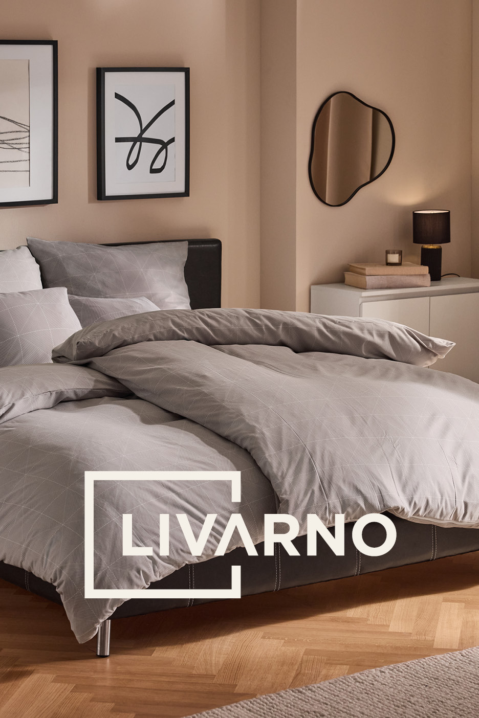 Grey patterned bedding set on a double bed in a modern bedroom.
