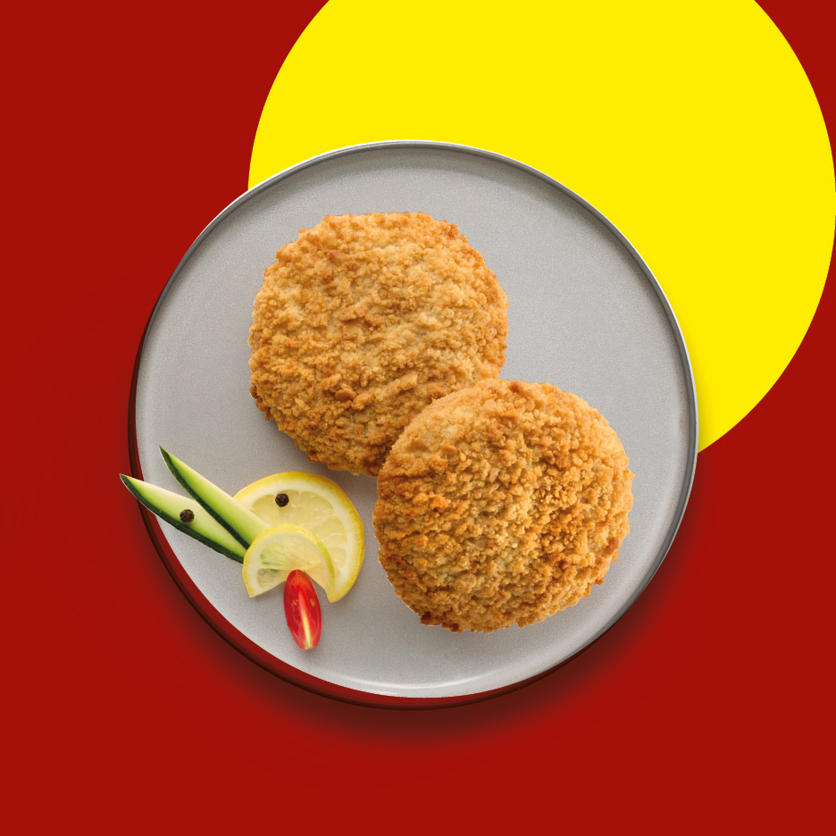 Two golden-brown breaded fish cakes on a plate with lemon and cucumber garnish.