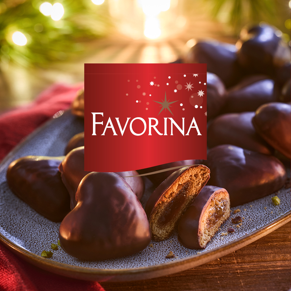 Favorina gingerbread hearts with chocolate coating and fruit filling, on a festive plate.