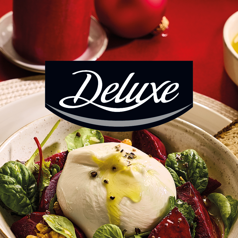 Deluxe logo over a burrata salad with beetroot, spinach, and walnuts.