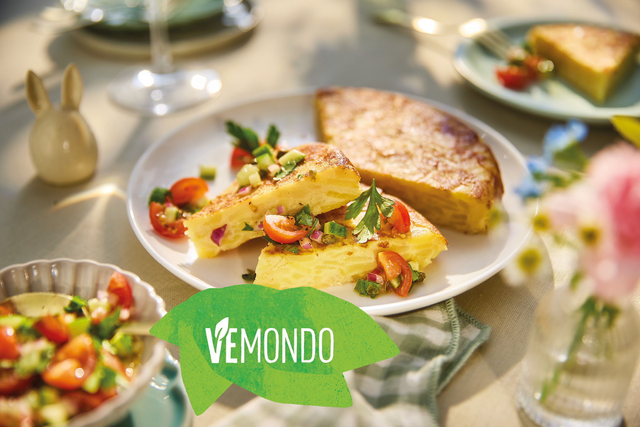 Vemondo vegan Spanish omelet slices with fresh salad on a table setting.