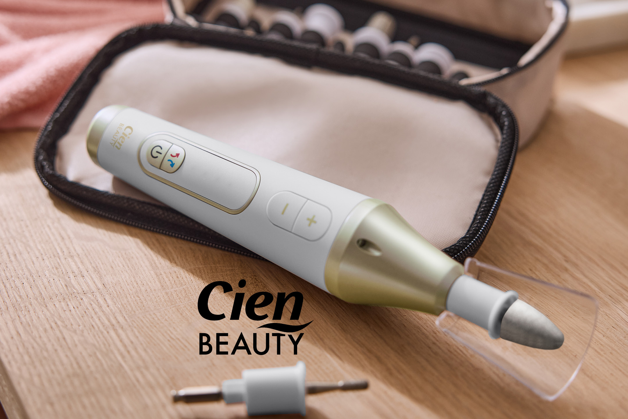 Electric manicure and pedicure set with various attachments, on a wooden surface.