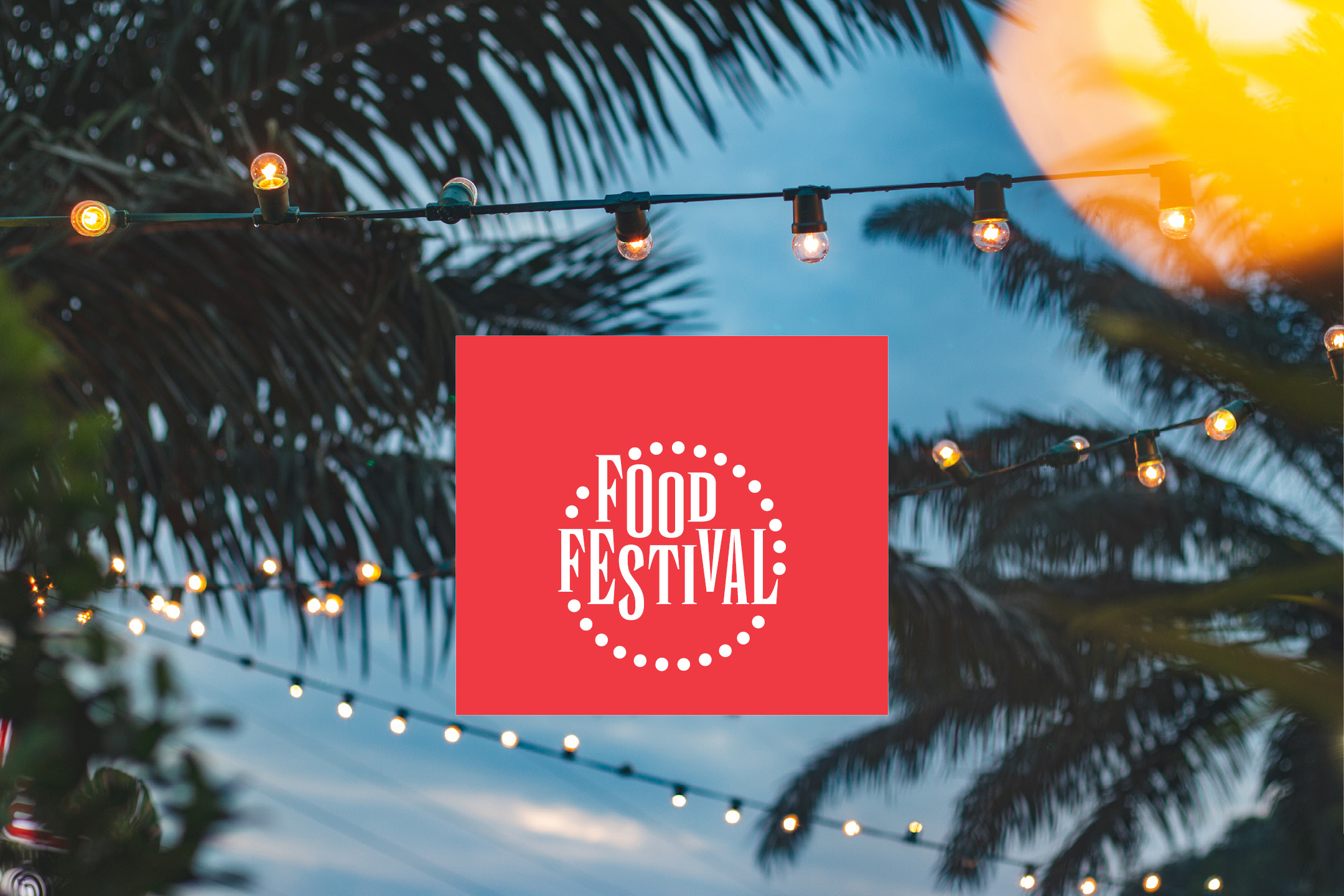 Food Festival sign with string lights and palm trees in the background.