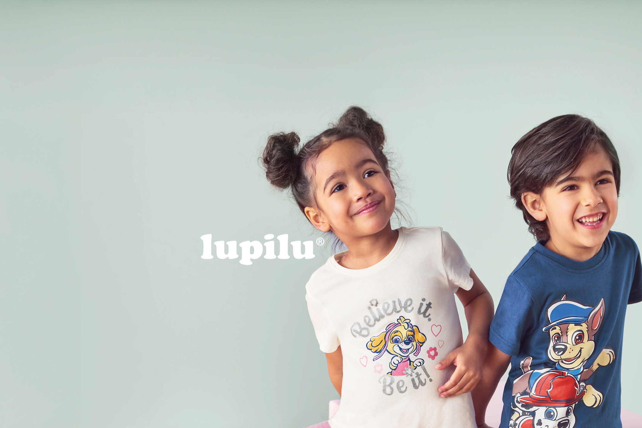 Two smiling children wearing Paw Patrol themed t-shirts, one with Skye and the other with Chase and Marshall.