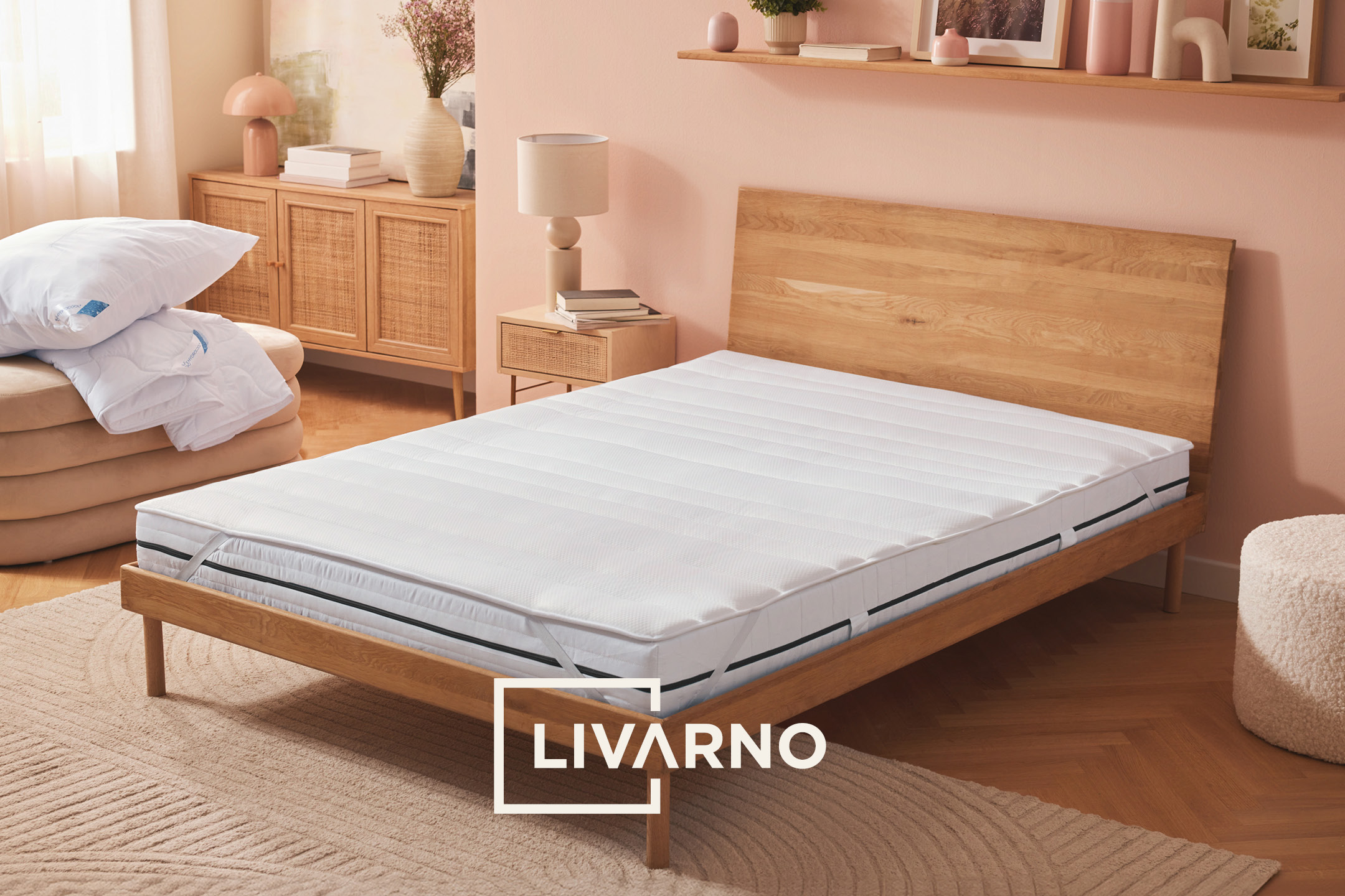 Bedroom with a wooden bed frame, mattress, and a stack of pillows and duvets.