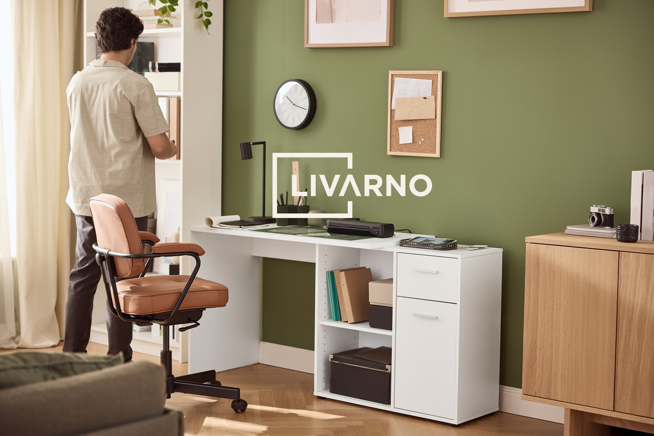 Home office with a white desk, brown chair, and green wall with a LIVARNO logo.