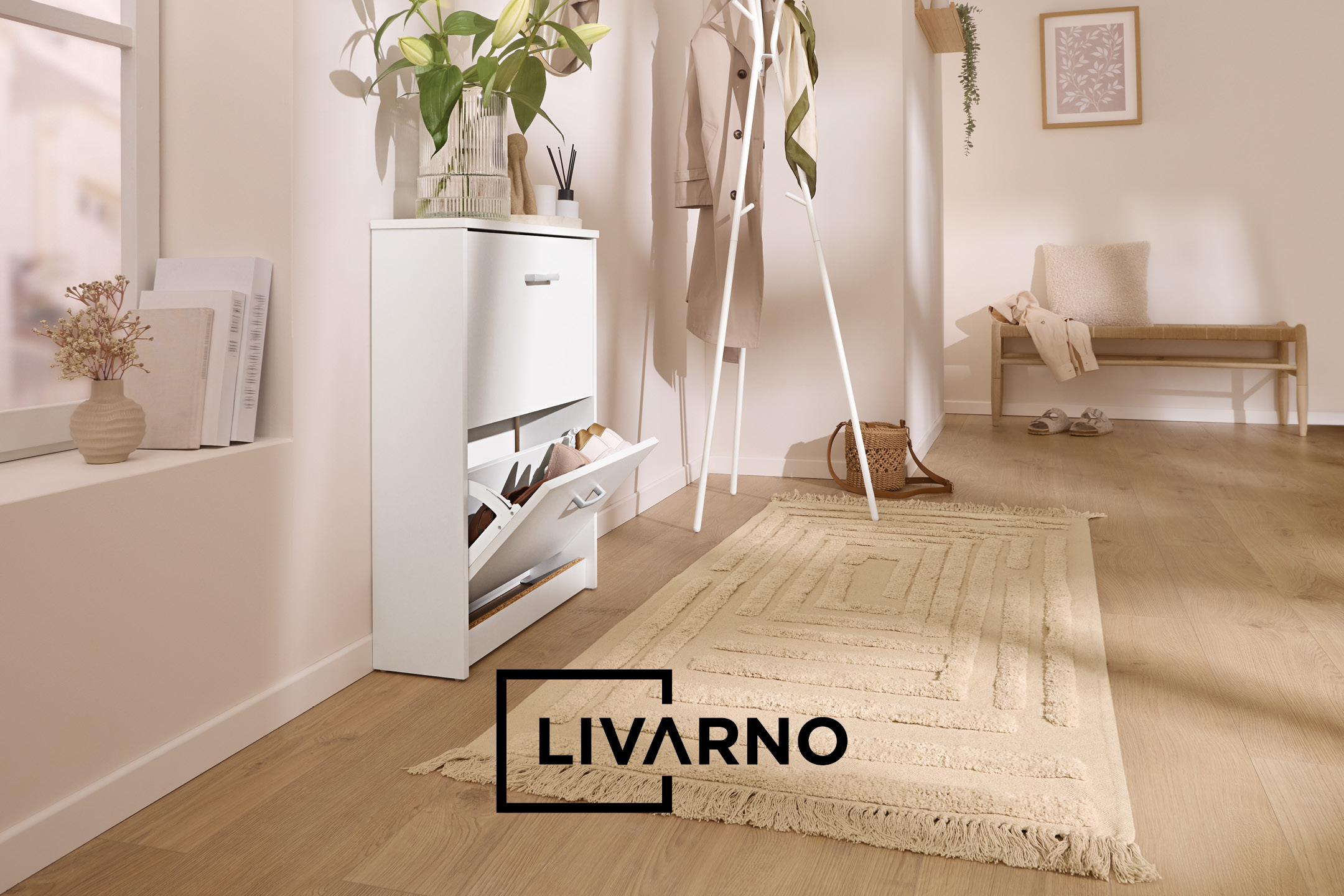 A bright entryway with a white shoe cabinet, coat rack, and a wooden bench, featuring the text 'LIVARNO'.
